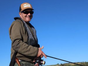 Un pêcheur sur un bateau au lac de la Ganguise, tout sourire.