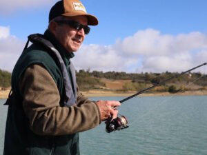 Un pêcheur sur un bateau au lac de la Ganguise en action de pêche.