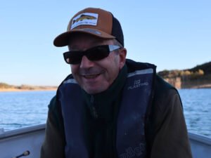 Un pêcheur, photo en mode portrait, sur un bateau au lac de la Ganguise.